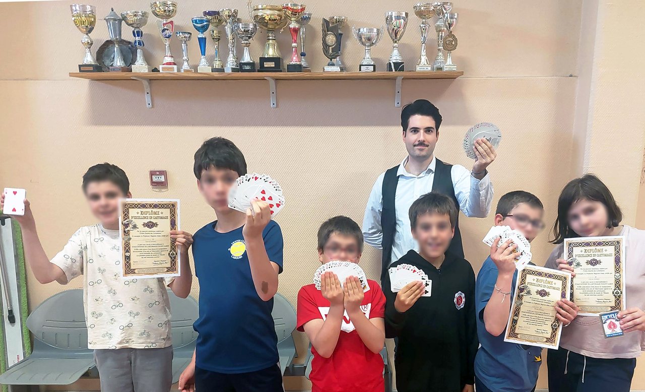 Enfants tenant cartes et diplômes après un stage de magie encadré par Alain Ackermann